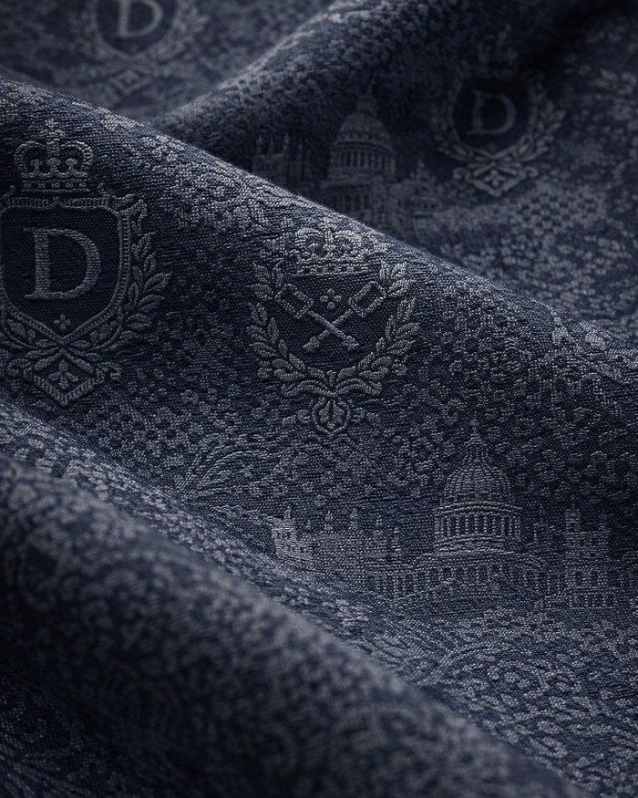Close-up of a navy custom jacquard fabric woven with a crest, crown and cathedral motif